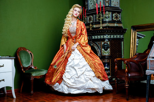 Retro Baroque Fashion Blonde Woman Wearing Gold Dress.