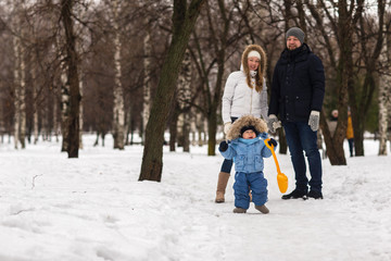 Fototapeta na wymiar Happy young family walking in a winter park