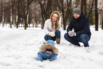 Obraz premium Happy young family walking in a winter park