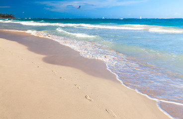 Empty sandy beach with footsteps in sand