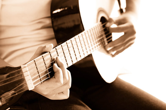 Girl playing guitar,hand focus sepia tone.