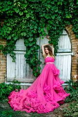 Obraz na płótnie Canvas Beautiful woman in gorgeous pink dress outdoors . Full length Portrait.