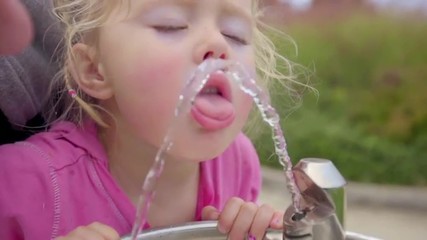 Close up shot of little girl at drinking fountain 
