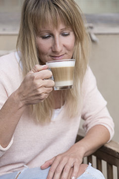 Frau trinkt Milchkaffee