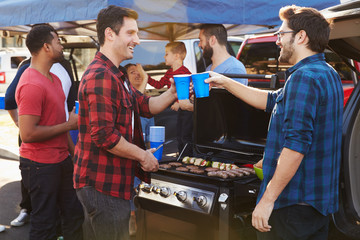 Group Of Sports Fans Tailgating In Stadium Car Park