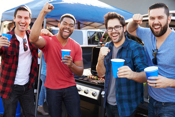 Group Of Male Sports Fans Tailgating In Stadium Car Park