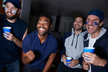 Group Of Male Sports Fans Watching Game On Television