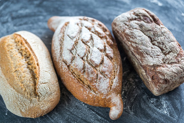 Whole grain breads on the dark wooden background