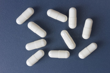 Ten white pills on a blue-gray surface
