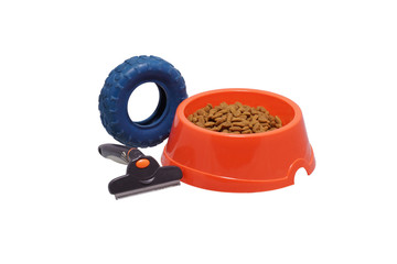 A bowl of dog food, toys and a comb.