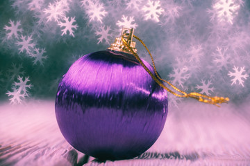Close up of decorative ball against bokeh in the form of snowfla