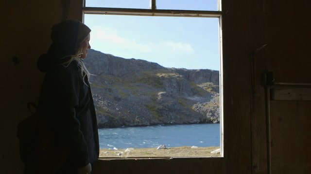 Expeditioner exploring an abandoned town in Northern Quebec. Pan Right