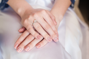 Obraz na płótnie Canvas Bride hand with manicure on wedding dress