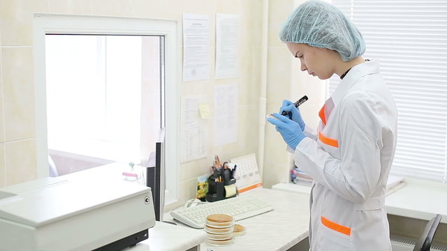 Microbiology laboratory, inspecting petri dish