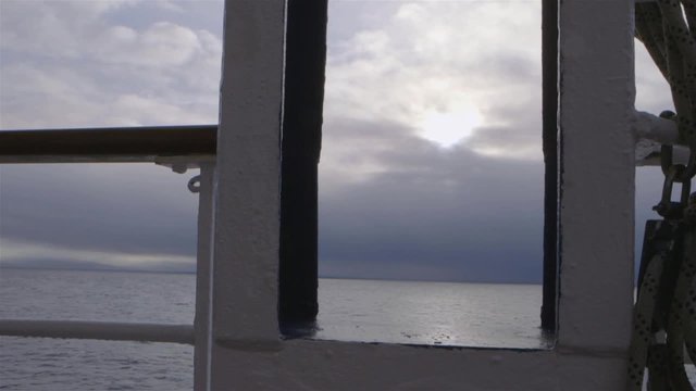 Slow Motion ocean view through the railing of an cruise ship. Tilt Up