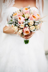 Vintage wedding bouquet with english roses at hands of bride at vintage dress