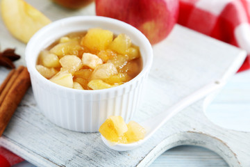 Apple jam in bowl on a white wooden table
