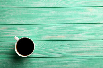 Cup of coffee on a mint wooden table