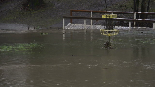 A footbridge and a disc golf basket surrounded by floodwaters of Hess Creek in December 2015 at Herbert Hoover Park in Newberg, Oregon.