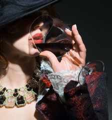 The girl is drinking red wine