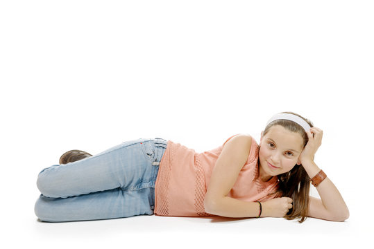  smiling little girl lying on the floor isolated on white backgr