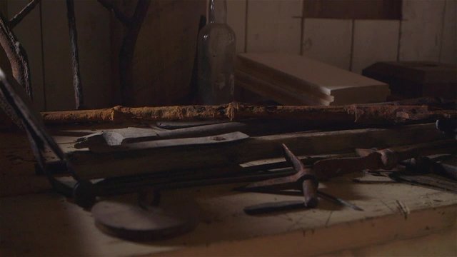 Old rusted cast iron tools displayed on a work bench.
