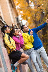 Young friends doing selfie after jogging.They standing against the wall.