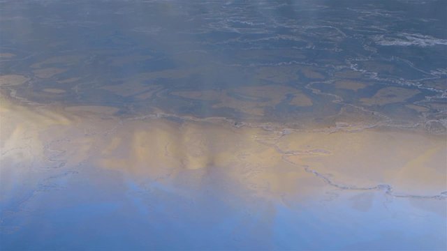 Thin layer of ice covering water.