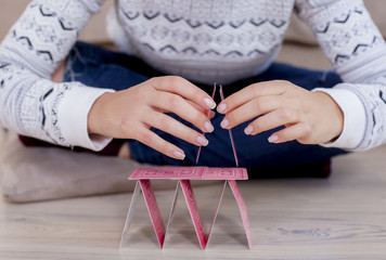 Womans hand building a house out of cards