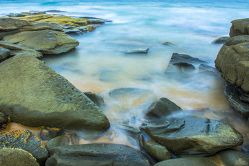 Fototapeta na wymiar Rocks and waves at Point Cartwright beach in the afternoon. Sunshine Coast, Queensland.