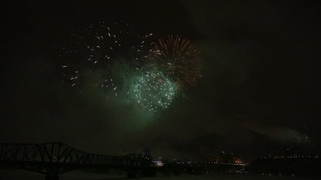 Slow motion fireworks over Alexandria Bridge crossing the Ottawa River during Winterlude.