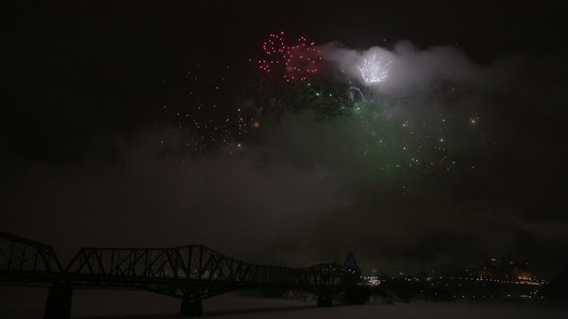 Slow motion fireworks over Alexandria Bridge crossing the Ottawa River during Winterlude.