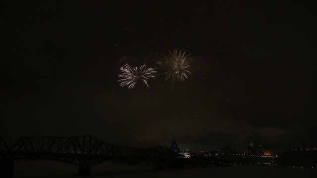 Slow motion fireworks over Alexandria Bridge crossing the Ottawa River during Winterlude.