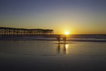 Fototapeta na wymiar surfers at sunset