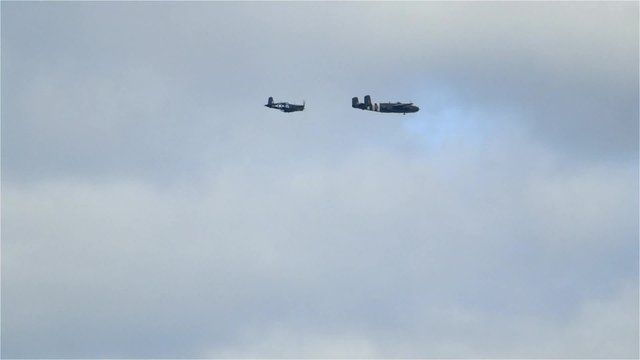 A North American B-25 Mitchell Plane and a Goodyear FG-1D Corsair fly closely together over Ottawa, Ontario.