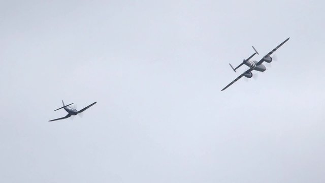A North American B-25 Mitchell Plane and a Goodyear FG-1D Corsair fly side by side over Ottawa, Ontario.