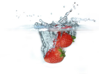 fresh strawberry dropped into water