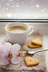 Cup of coffee, cookies in the shape of a heart and orchid on bac