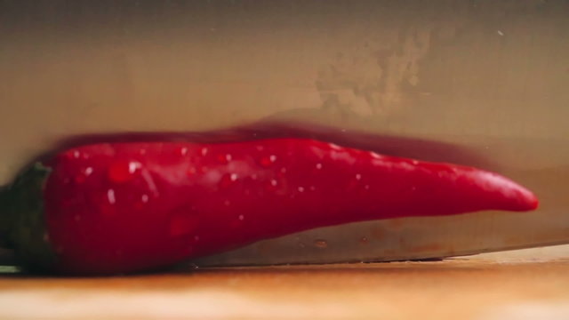 Close-up of cutting red hot pepper on cutting board