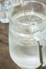 Glass jar of cold water on wooden table