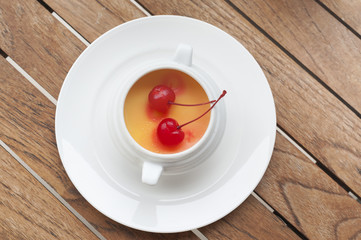 The creme brulee in ceramic with berries on wooden table