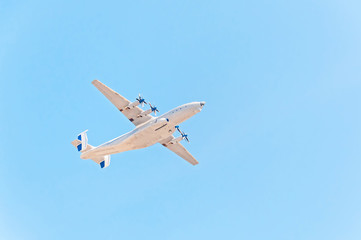 Antonov An-22 Antei (Antaeus, Cock) the world's largest turboprop-powered aircraft flies against blue sky background.
