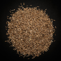 Top view of Organic Cumin seed (Cuminum cyminum) isolated on dark background.