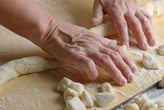 la nonna prepara i gnocchi mani in primo piano