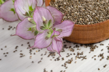 Chia seed healthy super food with flower over white wood backgro