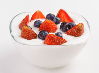 bowl full of yogurt with blueberries and strawberries