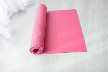 Pink yoga mat on gray floor at home.  Health concept.