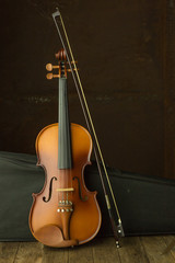 Fototapeta premium vintage violin resting against an old steel background