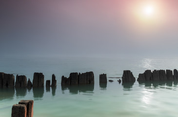 Pillars in water in a foggy morning