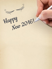 Hand writing "Happy New 2016!" on aged sheet of paper.